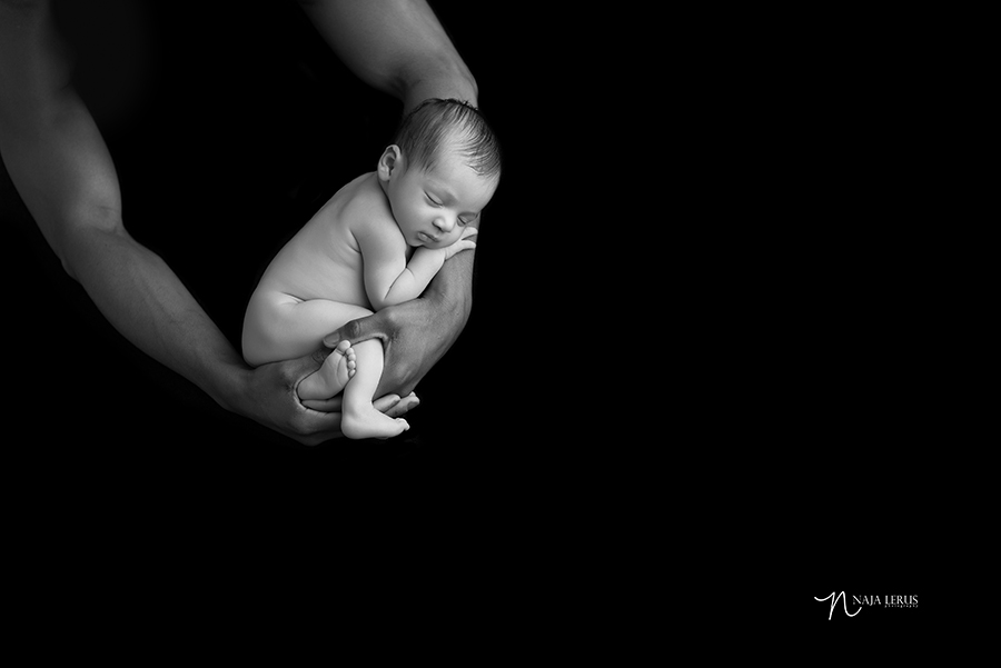 timeless black and white artistic newborn photography of baby in father's arms