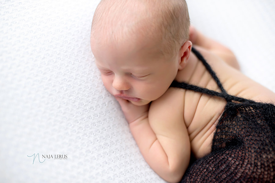 close up newborn baby dressed overalls chicago