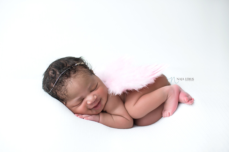 newborn baby with angel wings smiling photographer chicago