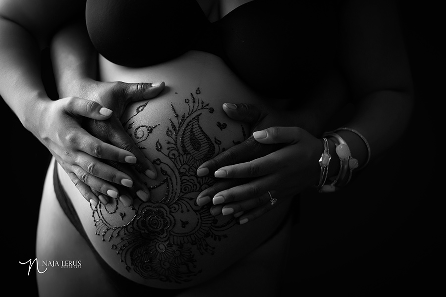 black and white couple hands on pregnant stomach 