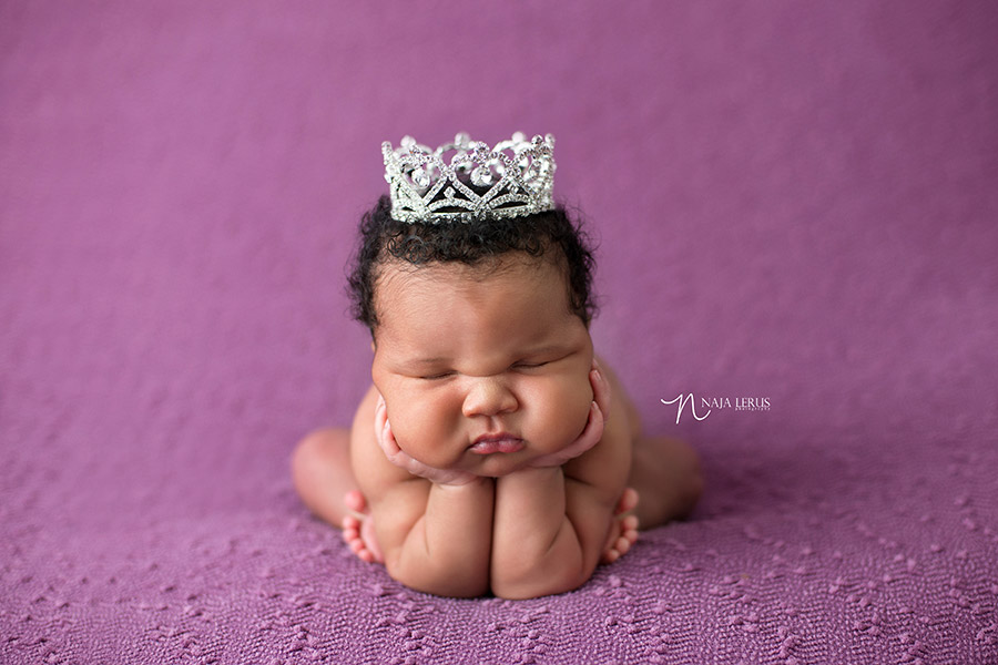 newborn with crown hands in cheeks chicago photographer