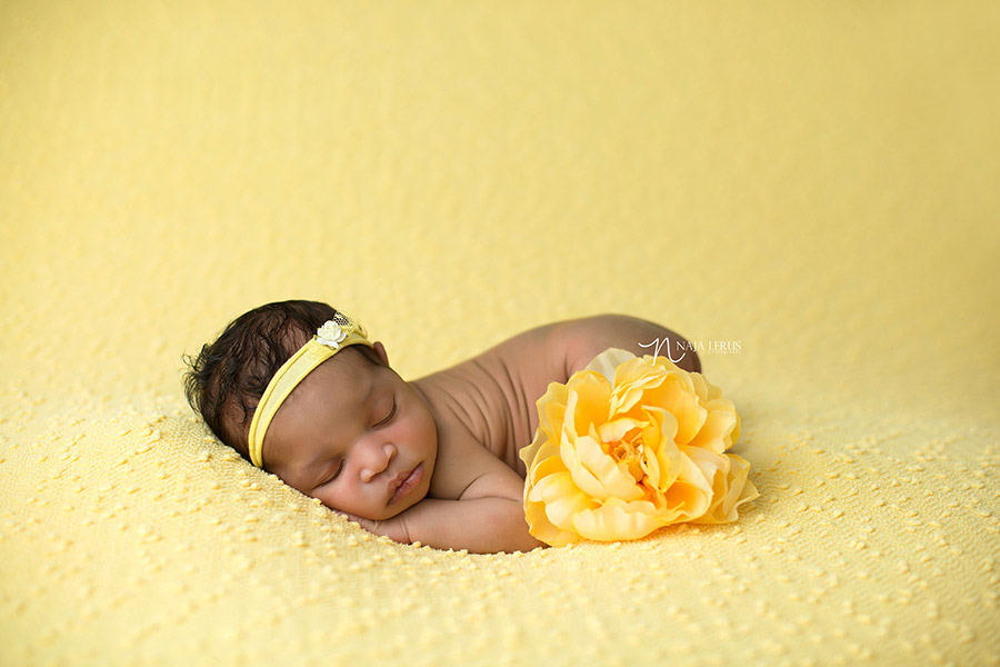 newborn baby posed with flower