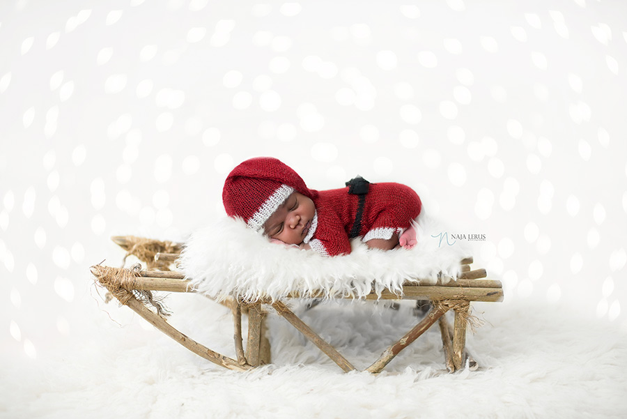 christmas holiday newborn baby picture on sled chicago photographer